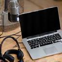 Microfone, fones e computador prontos para podcast